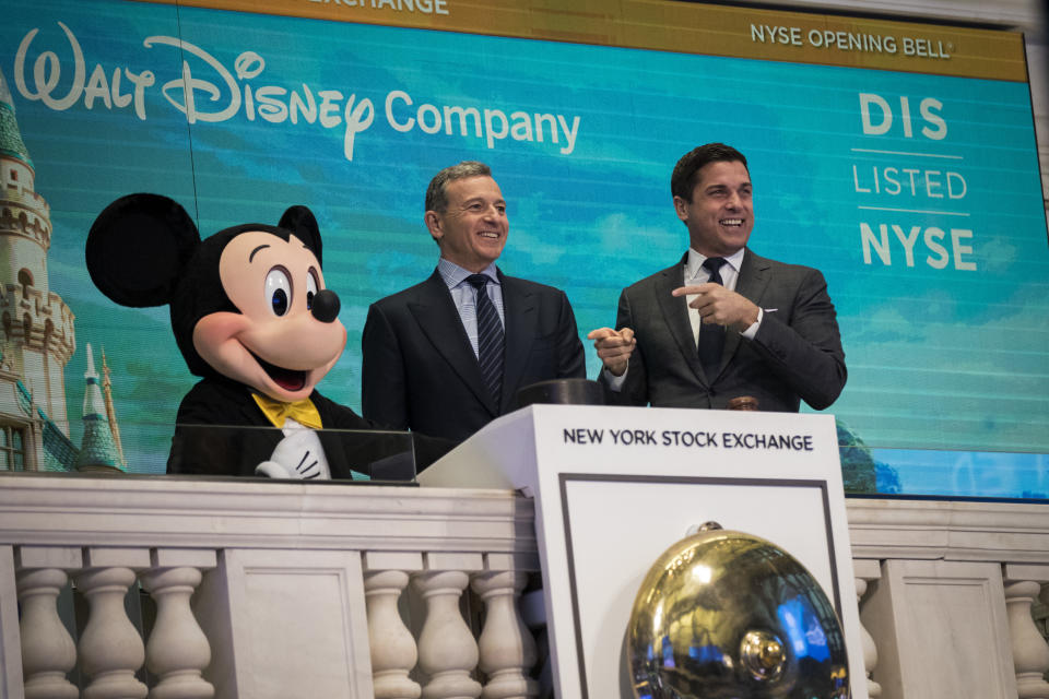 Disney CEO Bob Iger, middle, at the New York Stock Exchange with Mickey Mouse.