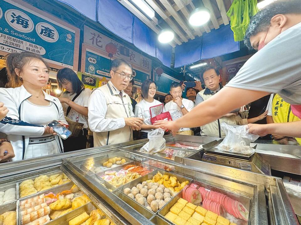 台南市長黃偉哲（前排左二）在東菜市採買魚丸等美食，希望透過與外送平台攜手合作，為傳統市場注入新活力。（曹婷婷攝）