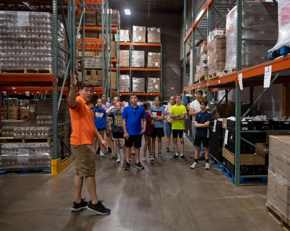 Volunteer Lead Sean Presley gives a tour of the Tri-State Food Bank facility to volunteers from St. John the Baptist Catholic Church youth group in Evansville, Ind., Wednesday morning, June 22, 2022.