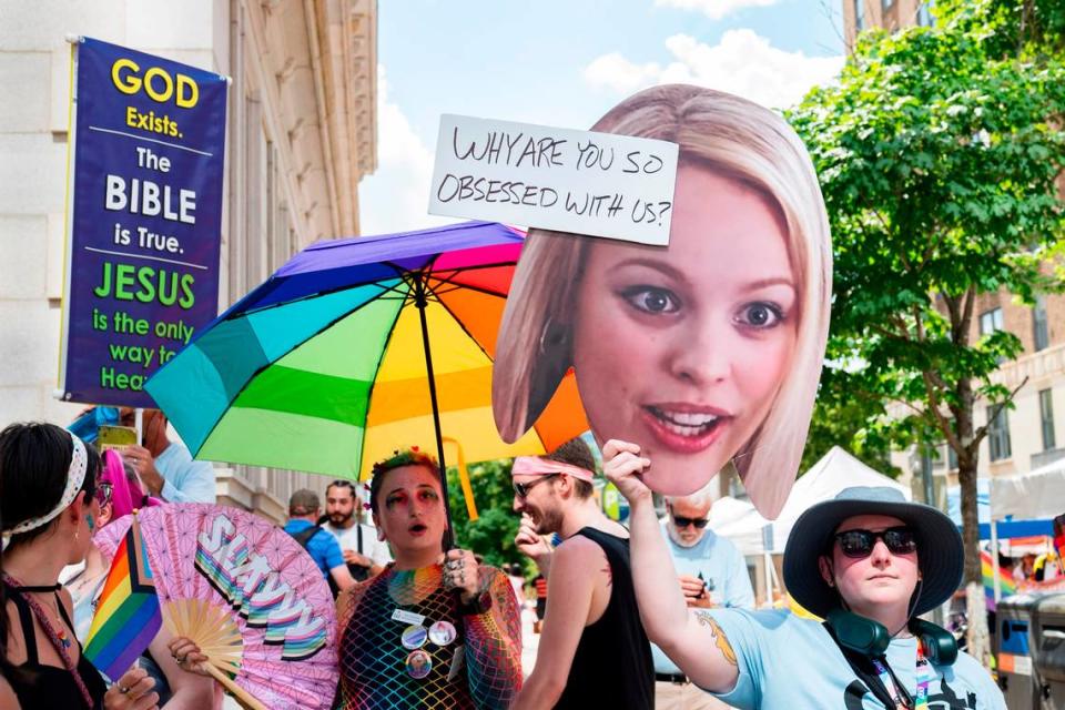 Pride festivalgoers hold up umbrellas and signs to block out individuals preaching over loud speakers and holding signs with anti-LGBTQ+ messages at Raleigh Pride on Saturday, June 22, 2024.