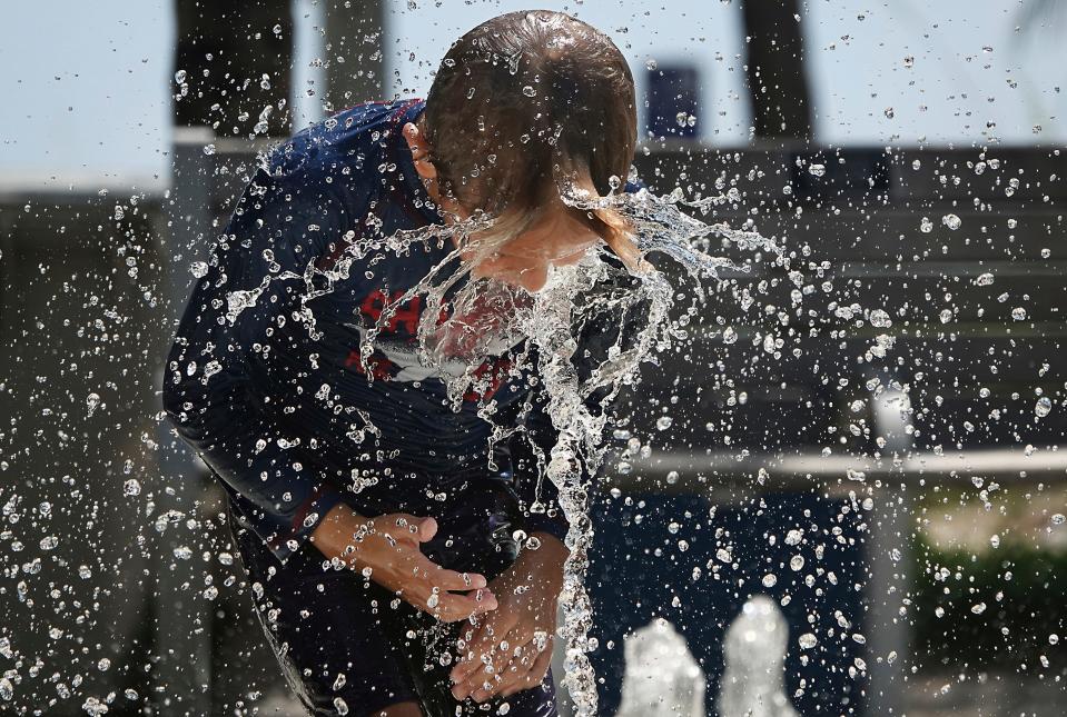 Anthony Danesi of Coconut Creek runs through the splashpad at Pompano Beach, Fla., Wednesday, June 14, 2023. The National Weather Service issued a heat index warning with "feels like" temperatures above 105 degrees across South Florida.