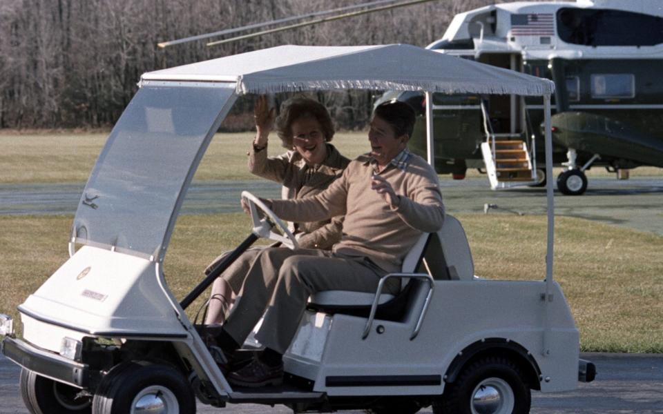 Margaret Thatcher and Ronald Reagan in a golf cart at Camp David in 1984 - AP