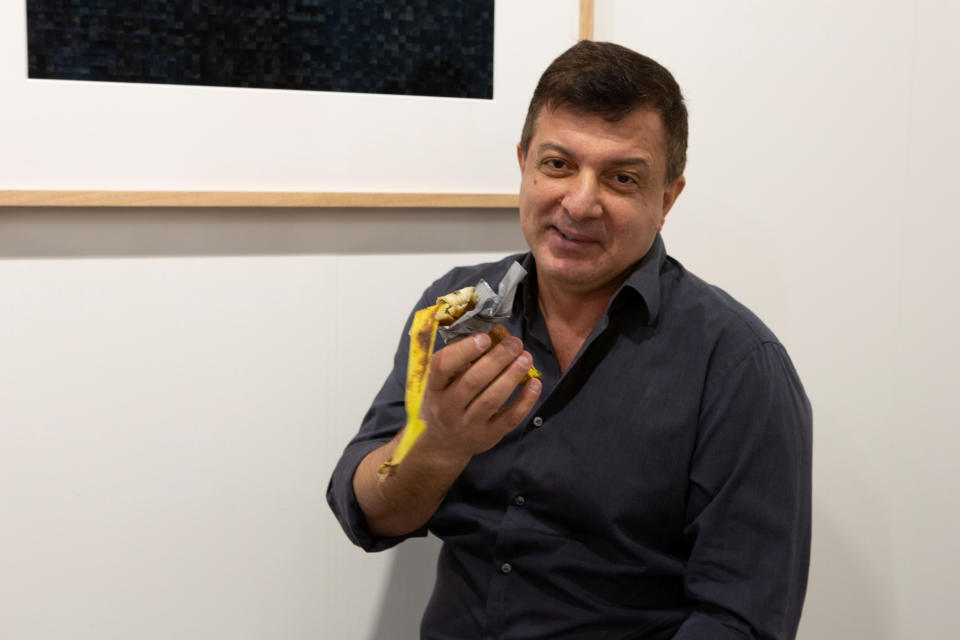 David Datuna shows the remains of the artwork 'Comedian' by the artist Maurizio Cattelan at Perrotin stand in Art Basel in Miami Beach, Florida, December 7, 2019.  REUTERS/Eva Marie Uzcategui