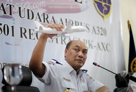 Soerjanto Tjahjono, the head of Indonesia's National Transportation and Safety Committee, holds a model plane during a news conference to announce the NTSC's findings in the investigation of the AirAsia QZ8501 crash, in Jakarta, Indonesia December 1, 2015. REUTERS/Garry Lotulung