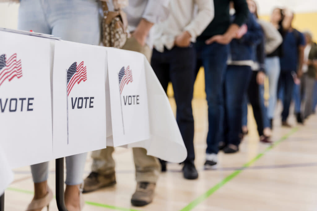 A low angle view of a long line of people waiting to vote in the elections.