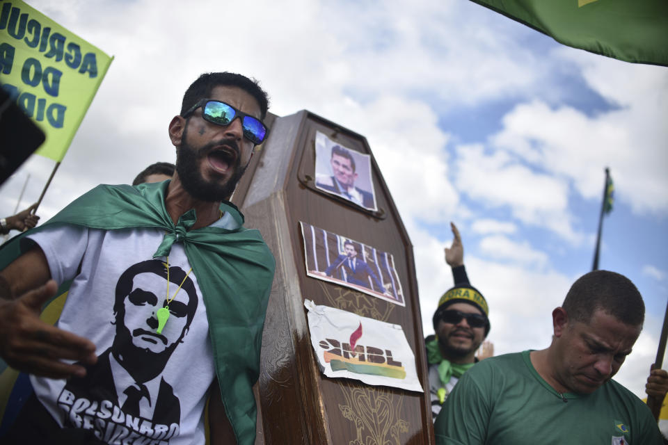 FILE - Supporters of Brazil's President Jair Bolsonaro carry a coffin with images of the resigned former Justice Minister Sergio Moro taped to it, during a protest against the Supreme Court and Brazil's National Congress, in Brasilia, Brazil, Sunday, May 17, 2020. The anti-corruption crusader had Brazil's former President da Silva jailed. But then the Supreme Court ruled that Moro had been biased against Luiz Inacio Lula da Silva by colluding with prosecutors to secure a conviction. (AP Photo/Andre Borges, File)