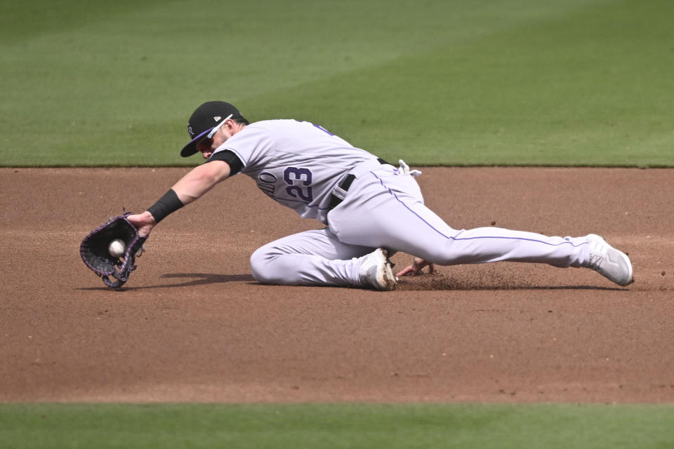 Colorado Rockies first baseman Kris Bryant (23) makes a sliding stop on a single hit by San Diego Padres' Xander Bogaerts during the first inning of a baseball game Wednesday, Sept. 20, 2023, in San Diego. (AP Photo/Denis Poroy)