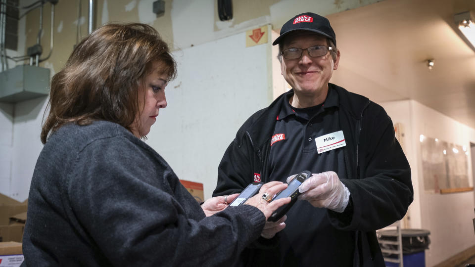 This Oct. 20, 2019 photo released by 412 Food Rescue shows a volunteer using the Food Rescue Hero app to check in at a Pittsburgh grocery store to pick up donated food. While millions of people struggle with food insecurity and hunger nationwide, the USDA estimates that more than 30% of the food in America is wasted each year. (Monica Godfrey-Garrison/412 Food Rescue via AP)