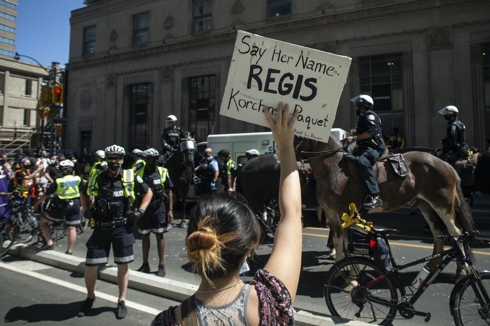 Protesters surround a court services vehicle in May 2021 as demonstrators mark the first anniversary of the death of Regis Korchinski-Paquet, who died in the presence of Toronto police officers. THE CANADIAN PRESS/Chris Young