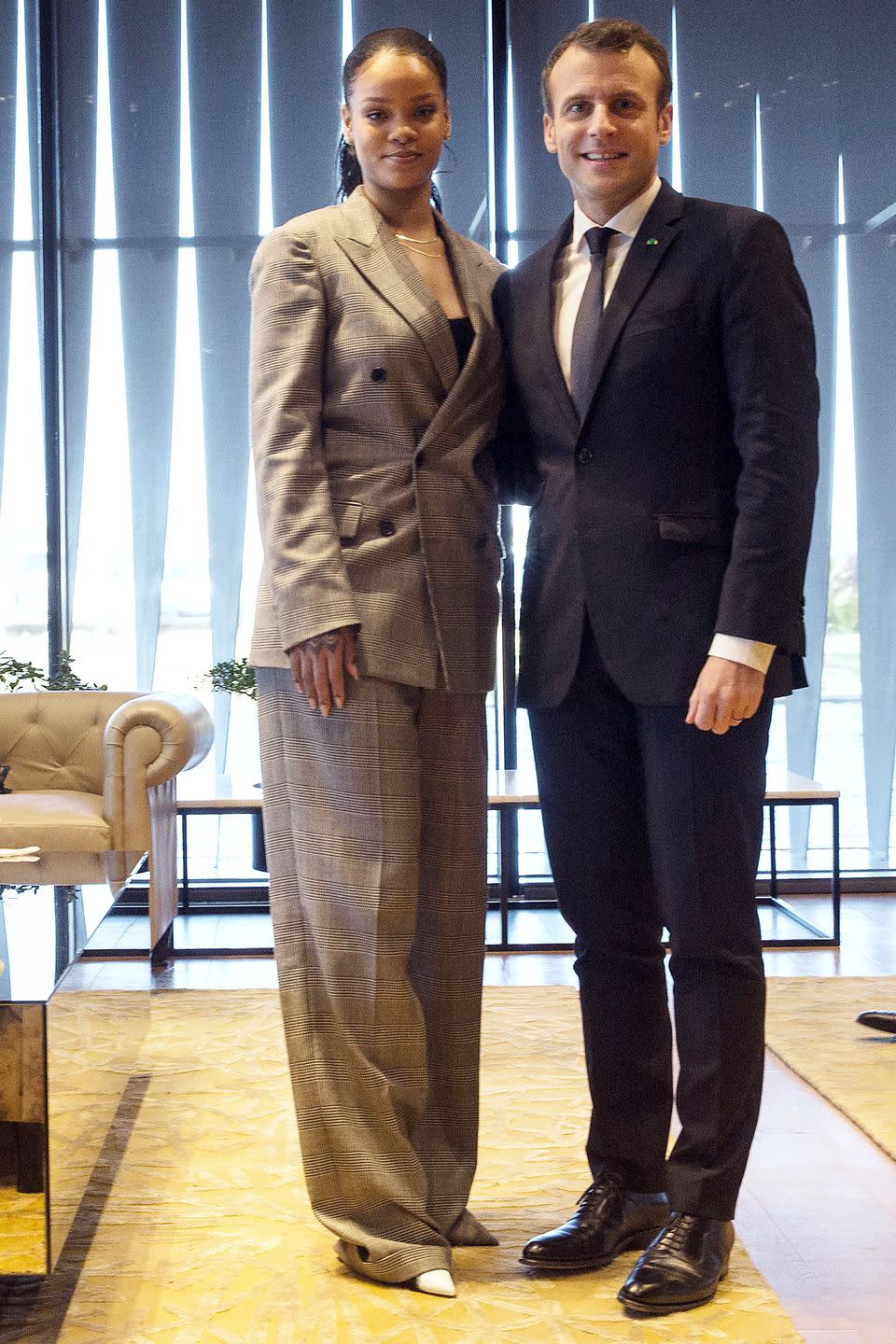 <p>Rihanna wears a gray plaid suit, white pumps, and thin gold necklaces while meeting Emmanuel Macron, the President of France, for a conference hosted by the Global Partnership for Education in Dakar, Senegal.</p>