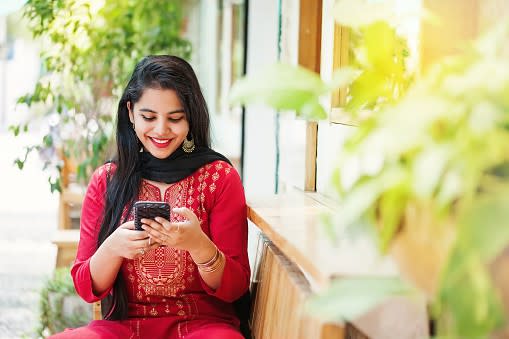 Young Indian woman looking at her smartphone