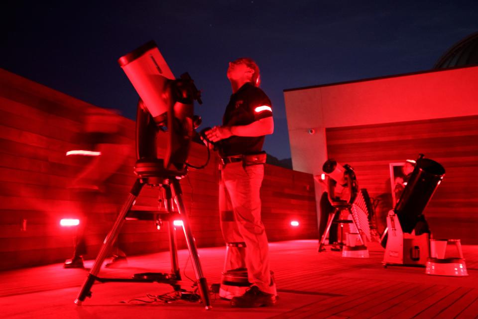 Astronomer Eric McLaughlin prepares for the stargazing event at the Rancho Mirage Observatory in Rancho Mirage, Calif., on July 21, 2022. To preserve human night vision, they work exclusively with red lighting.