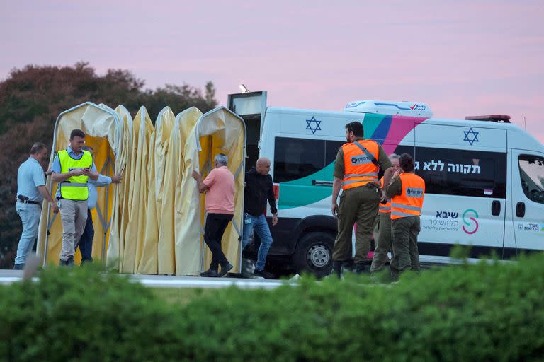 Las fuerzas de seguridad israelíes se encuentran junto a una ambulancia mientras el personal médico se preparaban para la llegada de rehenes israelíes que serían liberados por Hamás desde la Franja de Gaza en las afueras del centro médico Sheba de Ramat Gan en el distrito de Tel Aviv el 25 de noviembre de 2023 - (Créditos: @JACK GUEZ)