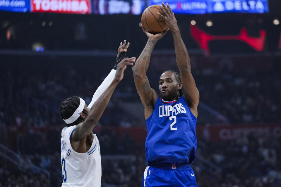 Los Angeles Clippers forward Kawhi Leonard, right, looks to shoot against Minnesota Timberwolves forward Jaden McDaniels during the first half of an NBA basketball game, Monday, Feb. 12, 2024, in Los Angeles. (AP Photo/Ryan Sun)