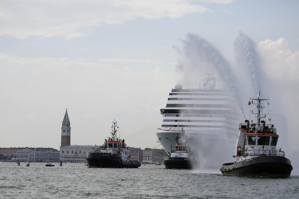 The the 92,409-ton, 16-deck MSC Orchestra cruise ship exits the lagoon as St. Mark's Square stands out in background, left, as it leaves Venice, Italy, Saturday, June 5, 2021. The first cruise ship leaving Venice since the pandemic is set to depart Saturday amid protests by activists demanding that the enormous ships be permanently rerouted out the fragile lagoon, especially Giudecca Canal through the city's historic center, due to environmental and safety risks. (AP Photo/Antonio Calanni)