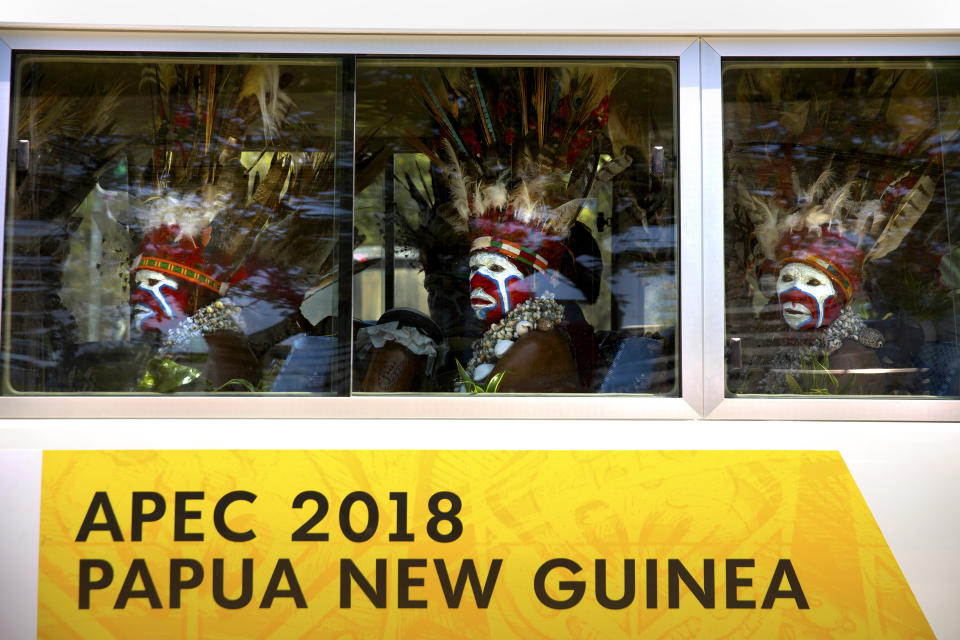 In this Nov. 14, 2018, file photo, men in traditional dress ride a shuttle bus ahead of the APEC Economic Leaders' Week Summit in Port Moresby, Papua New Guinea. (AP Photo/Mark Schiefelbein, File)