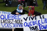 Women hold signs as they protest against Quebec's proposed Charter of Values in Montreal, September 14, 2013. Thousands took to the streets to denounce the province's proposed bill to ban the wearing of any overt religious garb by government paid employees. The signs read (L) "Quebec let us serve you" (R) "freedom in Quebec for all". REUTERS/ Christinne Muschi(CANADA - Tags: POLITICS CIVIL UNREST RELIGION)