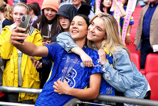 <p>John Walton/PA Images via Getty</p> Chelsea's Sam Kerr (left) poses with girlfriend Gotham FC's Kristie Mewis after victory in the Vitality Women's FA Cup Final at Wembley Stadium, London in May 2022