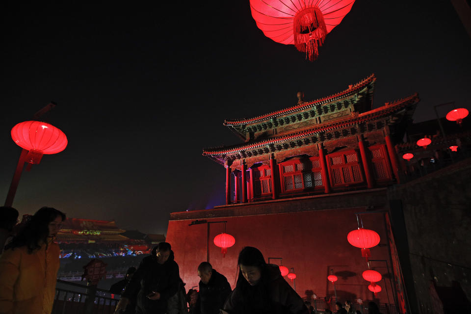 In this Tuesday, Feb. 19, 2019, photo, visitors tour the Forbidden City decorated with red lanterns and illuminated with lights for the Lantern Festival in Beijing. China lit up the Forbidden City on Tuesday night, marking the end of 15 days of lunar new year celebrations. It was not a Lantern Festival the last emperor, who abdicated in 1912, would have recognized. There were lanterns, but those lucky enough to snag tickets saw a laser light show and historic buildings bathed in colorful lights. Others watched from outside the vast walled compound in Beijing, from where Ming and Qing dynasty emperors ruled for five centuries. (AP Photo/Andy Wong)