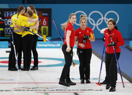 Curling - Pyeongchang 2018 Winter Olympics - Women's Round Robin - Britain v Sweden - Gangneung Curling Center - Gangneung, South Korea - February 18, 2018 - Anna Hasselborg, Sara McManus, Agnes Knochenhauer and Sofia Mabergs of Sweden (L) celebrate beating Eve Muirhead, Anna Sloan, Vicki Adams and Lauren Gray of Britain. REUTERS/Cathal McNaughton