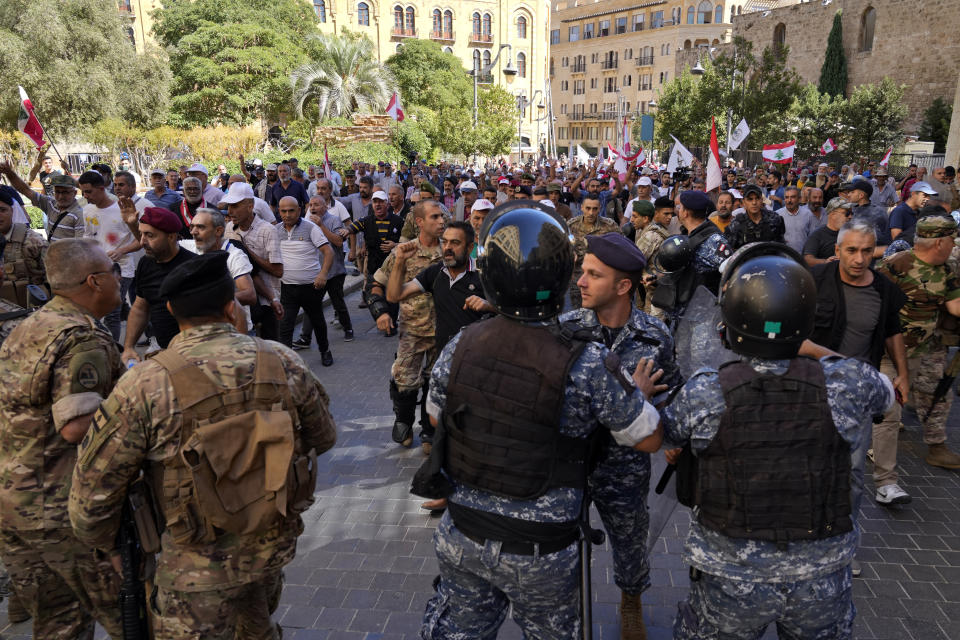 Army soldiers and riot police scuffle with retired members of the army as they try to enter to the parliament building while the legislature was in session, discussing the 2022 budget, during a protest in downtown Beirut, Lebanon, Monday, Sept. 26, 2022. The protesters demanded an increase in their monthly retirement pay, decimated during the economic meltdown. (AP Photo/Bilal Hussein)