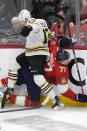 Boston Bruins center Charlie Coyle (13) and Florida Panthers defenseman Niko Mikkola (77) battle for the puck during the first period of Game 5 of the second-round series of the Stanley Cup Playoffs, Tuesday, May 14, 2024, in Sunrise, Fla. (AP Photo/Wilfredo Lee)