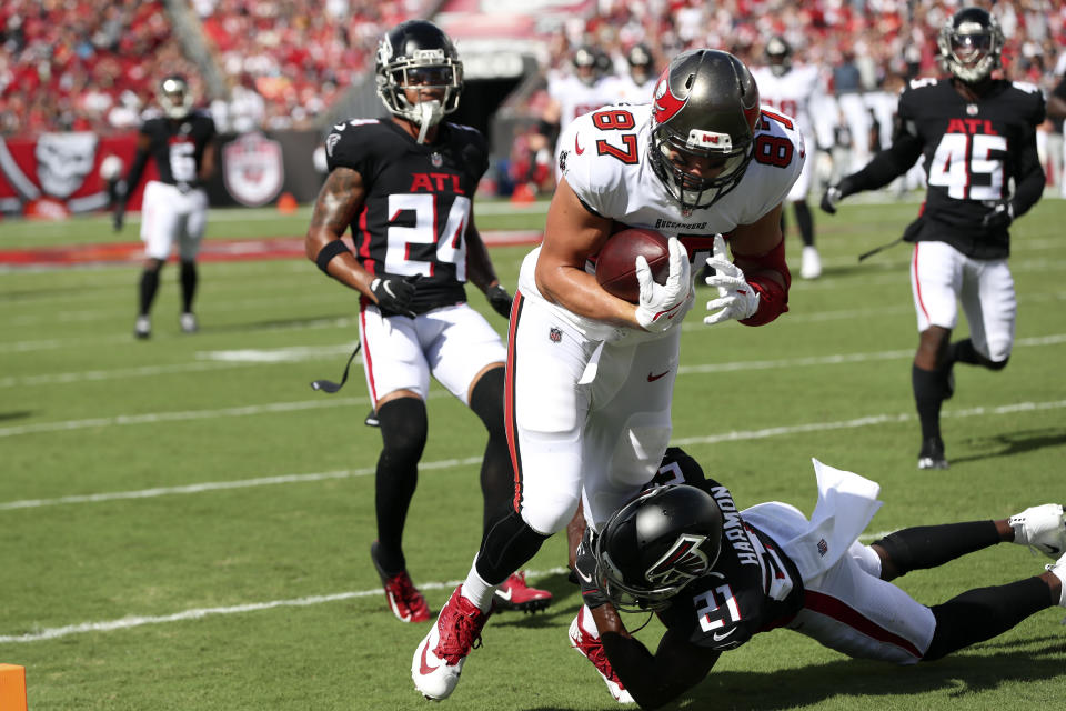 Tampa Bay Buccaneers tight end Rob Gronkowski (87) scores over Atlanta Falcons strong safety Duron Harmon (21) on a 20-yard pass from quarterback Tom Brady (12) during the first half of an NFL football game Sunday, Sept. 19, 2021, in Tampa, Fla. (AP Photo/Mark LoMoglio)