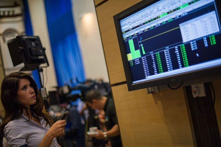 A woman looks at a digital display showing share prices after the listing debut of AirAsia X at Malaysia Stock Exchange in Kuala Lumpur on July 10, 2013. Shares in AirAsia X rose 1.60 percent on their market debut in Malaysia as the firm's chief executive promised a spending spree on new planes to boost frequency and target more routes