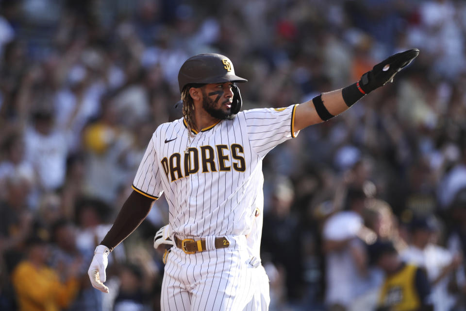 San Diego Padres' Fernando Tatis Jr. points toward second base after scoring on a double hit by Manny Machado in the fourth inning of a baseball game against the Cincinnati Reds, Saturday, June 19, 2021, in San Diego. (AP Photo/Derrick Tuskan)