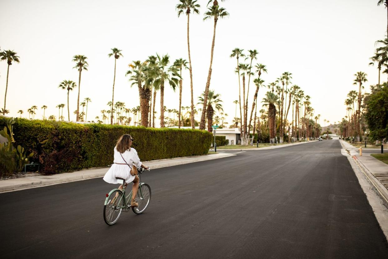 usa, california, palm springs, woman riding bicycle on the street