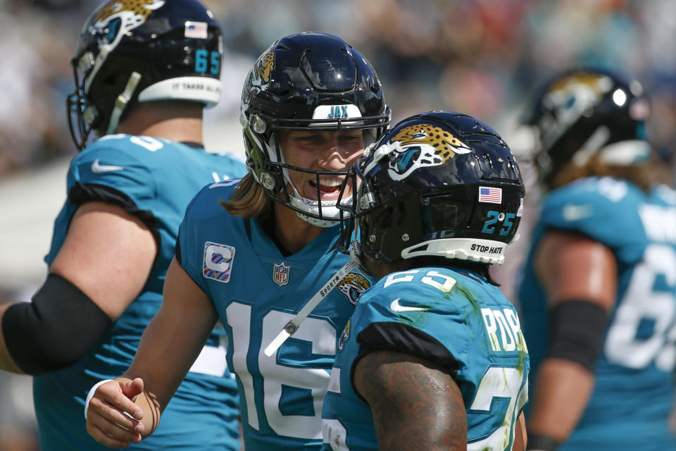 Jacksonville Jaguars quarterback Trevor Lawrence (16) celebrates with running back James Robinson after Robinson ran a 1-yard touchdown against the Tennessee Titans during the first half of an NFL football game, Sunday, Oct. 10, 2021, in Jacksonville, Fla. (AP Photo/Stephen B. Morton)