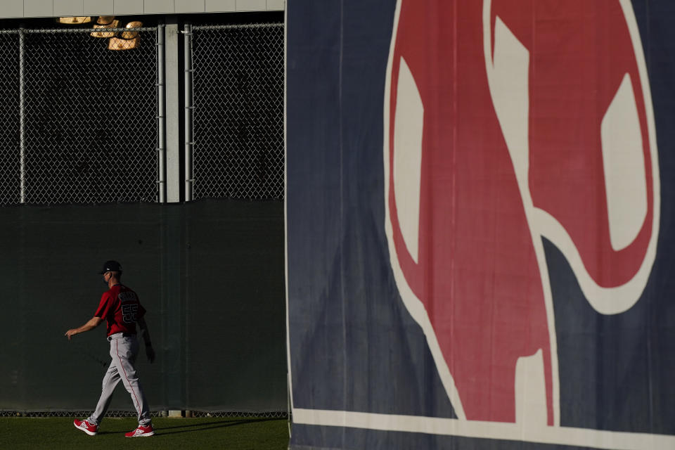 Boston Red Sox bullpen coach Kevin Walker strolls out to the field during spring training baseball practice on Monday, Feb. 22, 2021, in Fort Myers, Fla. (AP Photo/Brynn Anderson)