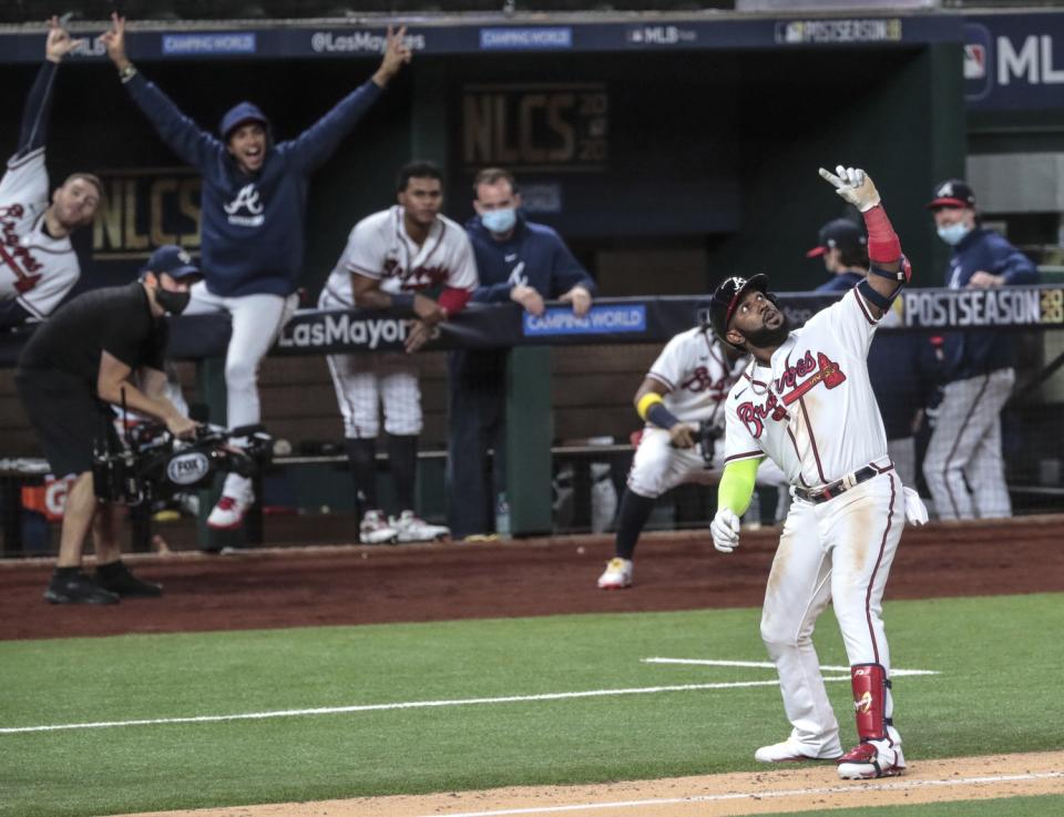 Atlanta Braves designated hitter Marcell Ozuna stops for an imaginary selfie.