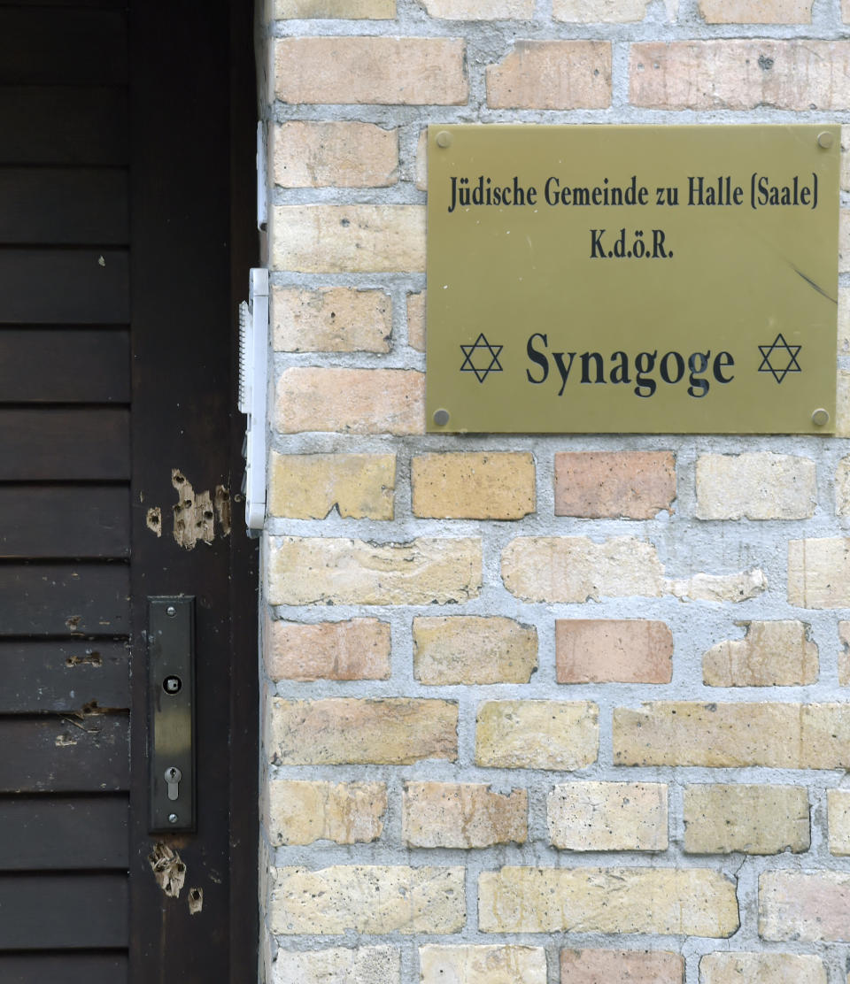 Bullet holes in the entrance door of a synagogue are pictured in Halle, Germany, Thursday, Oct. 10, 2019. A heavily armed assailant ranting about Jews tried to force his way into a synagogue in Germany on Yom Kippur, Judaism's holiest day, then shot two people to death nearby in an attack Wednesday that was livestreamed on a popular gaming site. (AP Photo/Jens Meyer)