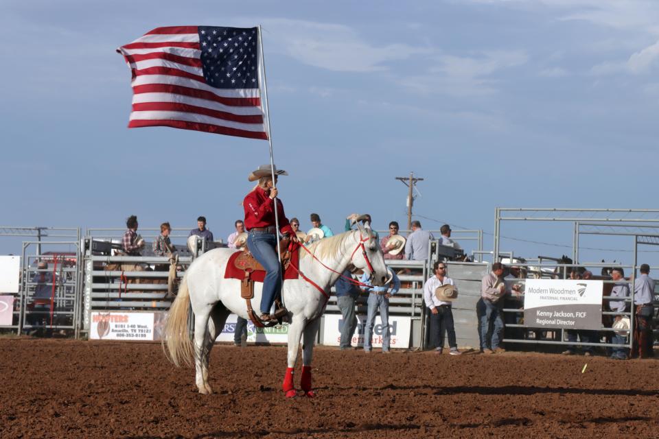 A member of the Will Rogers Range Riders Drill Team carries the American Flag to open the 78th Annual Will Rogers Range Riders Rodeo Thursday evening.