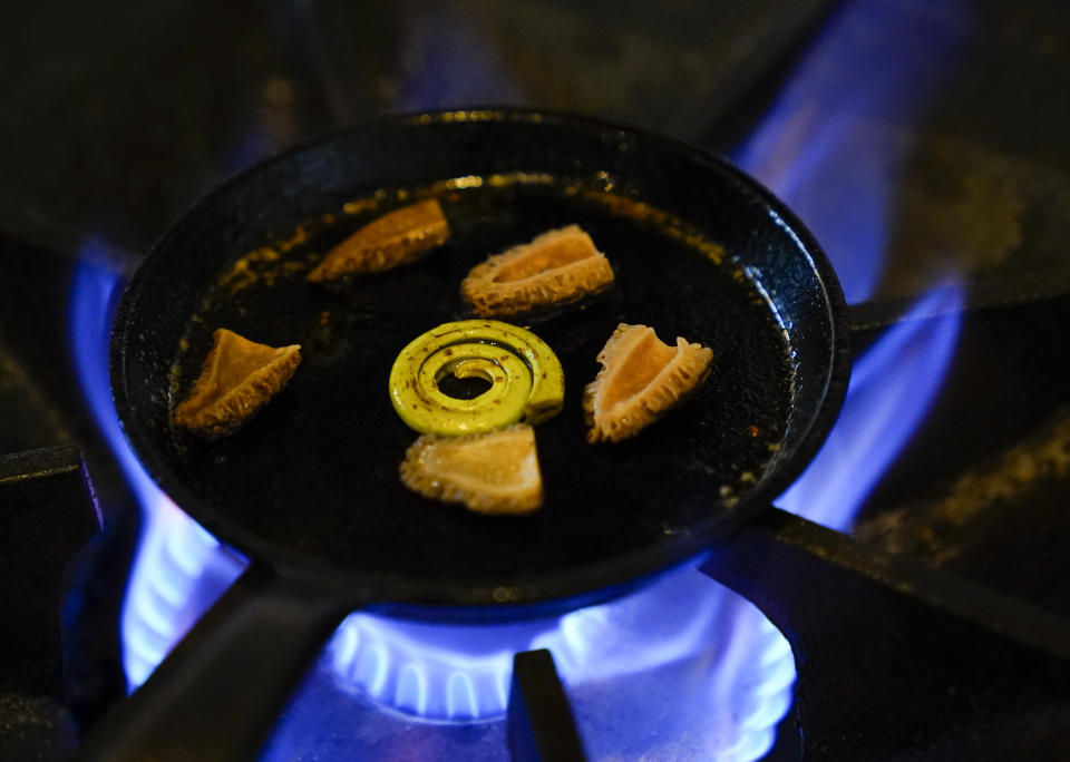 A fiddlehead and a morel sit on the stove while being prepared for Anak ni Bet, Archipelago's version of pinakbet, at the Filipino American restaurant on Wednesday, May 24, 2023, in Seattle. Chef Aaron Verzosa is nominated for a 2023 James Beard Award in the Best Chef: Northwest and Pacific category. (AP Photo/Lindsey Wasson)