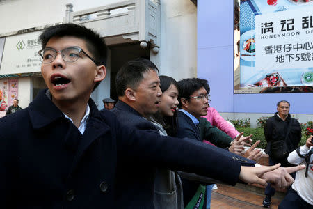 Pro-democracy activist Joshua Wong (L) urges people to vote for pro-democracy candidate Au Nok-hin (4th L) during a Legislative Council by-election in Hong Kong, China March 11, 2018. REUTERS/Bobby Yip