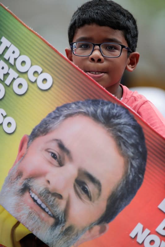 A boy holds a placard as supporters of former Brazilian President Luiz Inacio Lula da Silva wait for his arrival after he was released from prison, in Sao Bernardo do Campo