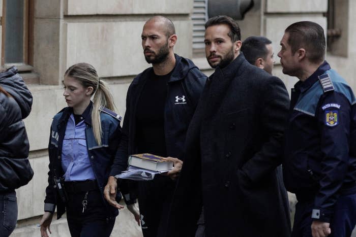 Andrew Tate and his brother, Tristan, are escorted by police officers outside the headquarters of the Bucharest Court of Appeal on Jan. 10.