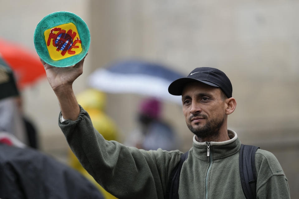 A demonstrator holds a bowl with the word "Hunger" written in Portuguese during a protest against Brazilian President Jair Bolsonaro, who is running for a second term, during independence bicentennial celebrations in Sao Paulo, Brazil, Wednesday, Sept. 7, 2022.