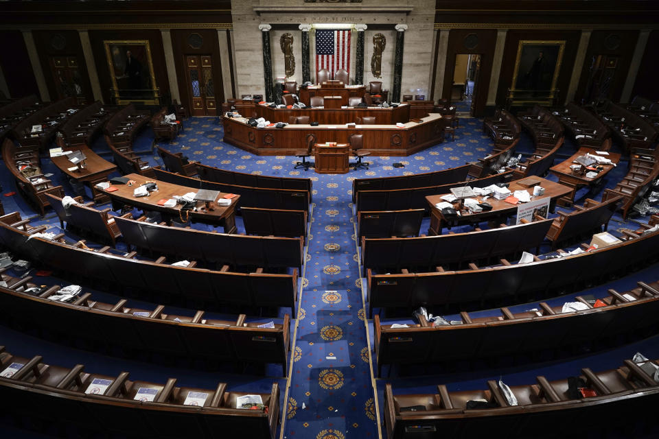 FILE - The House Chamber is empty after a hasty evacuation as rioters tried to break into the chamber at the U.S. Capitol on Wednesday, Jan. 6, 2021, in Washington. (AP Photo/J. Scott Applewhite, File)