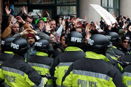 Protesters demonstrating against U.S. President Donald Trump raise their hands as they are surrounded by police on the sidelines of the inauguration in Washington, DC, U.S., January 20, 2017. REUTERS/Adrees Latif