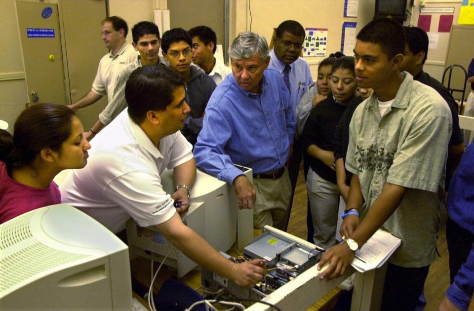4/23/01 Photo by Tim Chapman/Herald Staff,(Miami), Monday. Eric Robinson (CQ), (left), owner of Senior Networks, demonstrates to student Luis Chang(CQ),(right) and others in the classroom at Miami Senior High, how to install hardware to make the system high-speed wireless. Senator Bob Graham, (center) helps during one of his “Work Days”. This is for a business story by Bea Garcia and the school is at 2450 SW 1st Street.