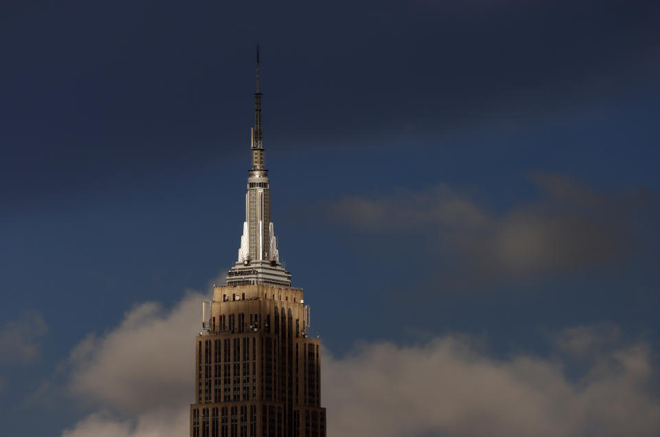 HOBOKEN NJ - AUGUST 22: The sun illuminates the spire on top of the Empire State Building as storm clouds pass through New York City on August 22, 2022, as seen from Hoboken, New Jersey.  (Photo by Gary Hershorn/Getty Images)