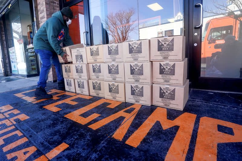 A worker stacks boxes of food distributed by the charity Lifecamp