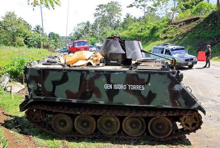 A government soldier in an armoured personnel carrier stands on guard at a checkpoint along a main highway in Pantar town, Lanao del Norte, after residents started to evacuate their hometown of Marawi city, southern Philippines May 24, 2017. REUTERS/Romeo Ranoco