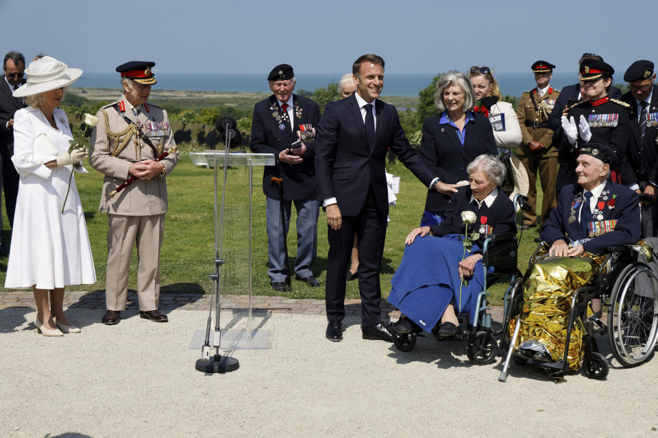 France's President Emmanuel Macron reacts after awarding 104-years-old British World War II veteran Christian Lamb, second right, who helped to plan the D-Day landings in Normandy, with the insignia of Knight in the Legion of Honor order, as Britain's King Charles III and Britain's Queen Camilla, left, looks on during a commemorative ceremony marking the 80th anniversary of the World War II D-Day Allied landings in Normandy, at the World War II British Normandy Memorial of Ver-sur-Mer, Thursday, June 6, 2024. Normandy is hosting various events to officially commemorate the 80th anniversary of the D-Day landings that took place on June 6, 1944. (Ludovic Marin/Pool via AP)