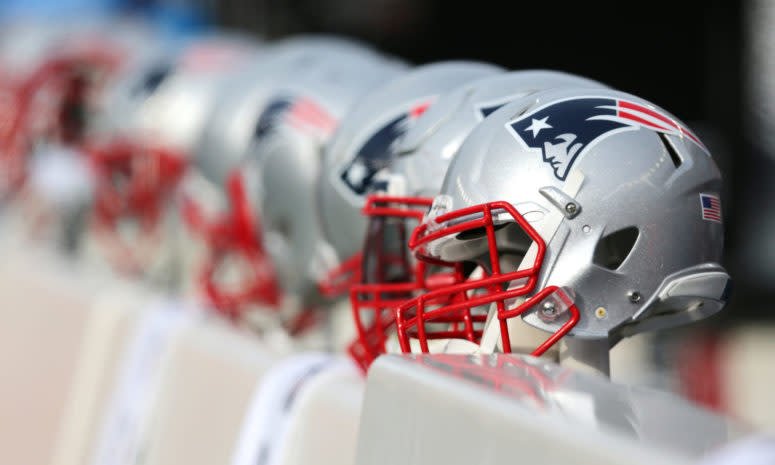 A New England Patriots helmet sitting on the bench.
