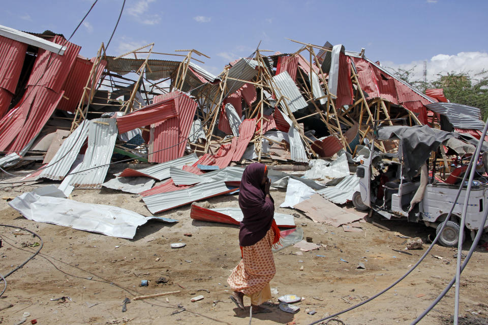 A Somali woman watch the destruction after car bomb attack on a European Union military convoy in the capital Mogadishu, Somalia Monday, Sept. 30, 2019. A Somali police officer says a suicide car bomber has targeted a European Union military convoy carrying Italian military trainers in the Somali capital Monday. (AP Photo/Farah Abdi Warsameh)