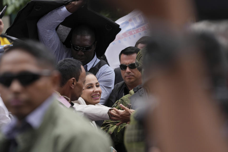 La aspirante presidencial Luisa González, del Movimiento Revolución Ciudadana, habla ante sus seguidores rodeada de seguridad a su salida de la Fiscalía General, adonde presentó una denuncia por un presunto plan para matarla en Quito, Ecuador, el lunes 18 de septiembre de 2023. Los ecuatorianos irán a segunda vuelta presidencial el 15 de octubre, tras el asesinato de uno de los candidatos presidenciales. (AP Foto/Dolores Ochoa)